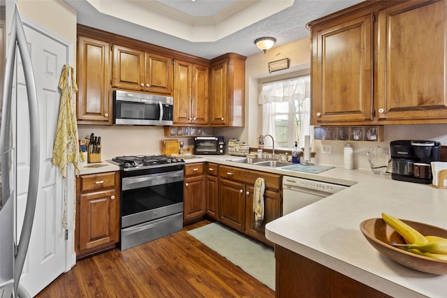 kitchen featuring appliances with stainless steel finishes, a textured ceiling, sink, and dark hardwood / wood-style floors