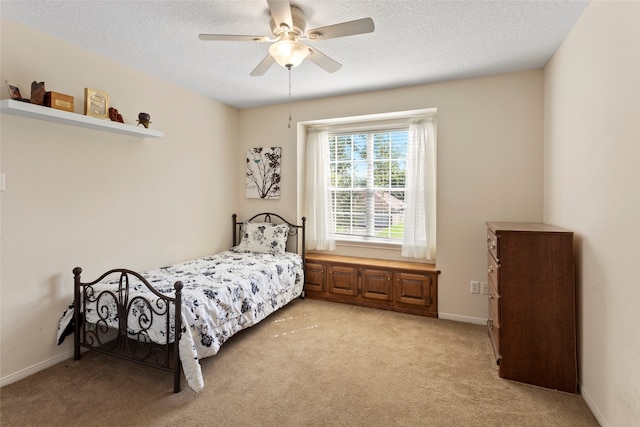 carpeted bedroom with ceiling fan and a textured ceiling