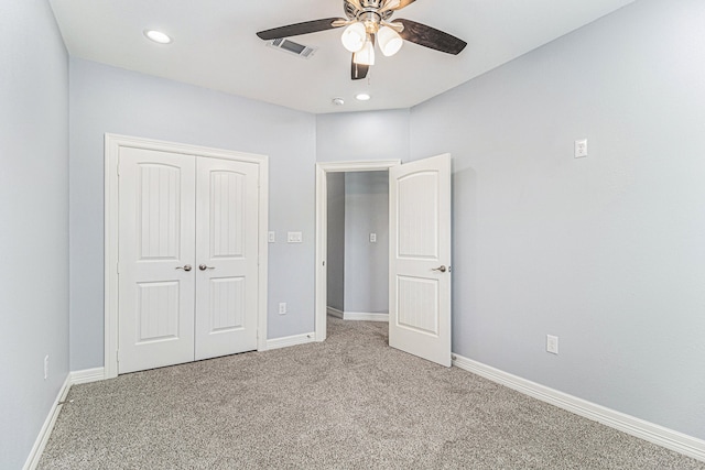 unfurnished bedroom featuring ceiling fan, a closet, and light colored carpet