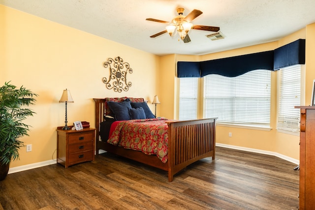 bedroom featuring ceiling fan, a textured ceiling, and dark wood-type flooring