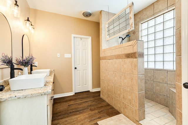 bathroom featuring wood-type flooring, a shower, and vanity