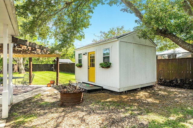 view of outbuilding featuring a pergola and a lawn