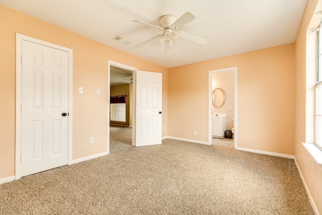 unfurnished bedroom featuring light carpet, connected bathroom, and ceiling fan