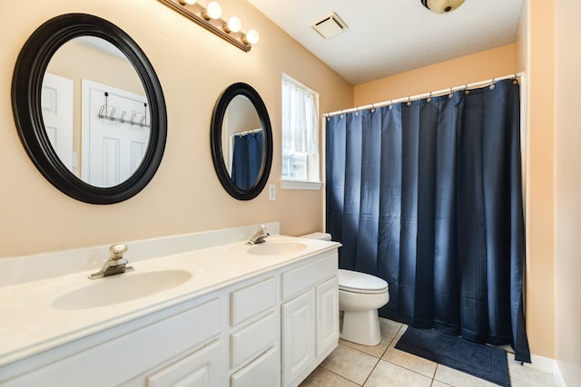 bathroom with vanity, toilet, a textured ceiling, and tile patterned floors