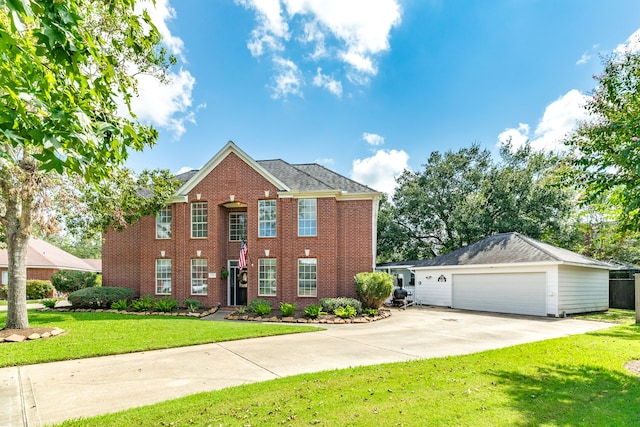 view of front of house with a garage, a front lawn, and an outbuilding