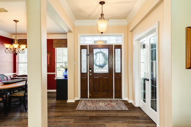 entryway featuring ornamental molding, dark wood-type flooring, and a notable chandelier