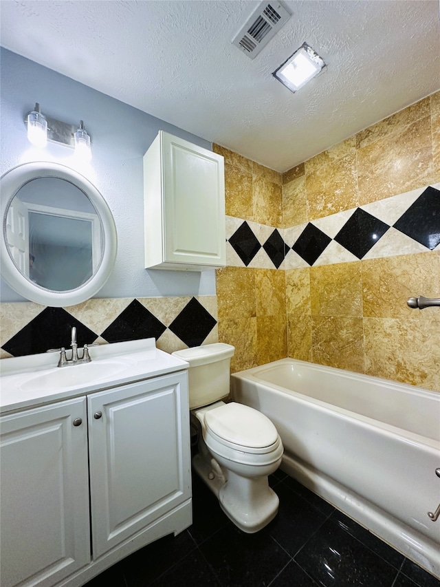 bathroom with a tub to relax in, a textured ceiling, vanity, and toilet