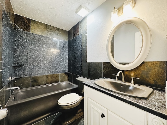 full bathroom with tile walls, a textured ceiling, tiled shower / bath, vanity, and toilet