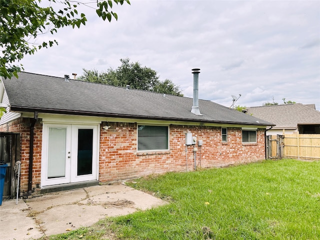 back of house featuring a lawn, a patio, and french doors