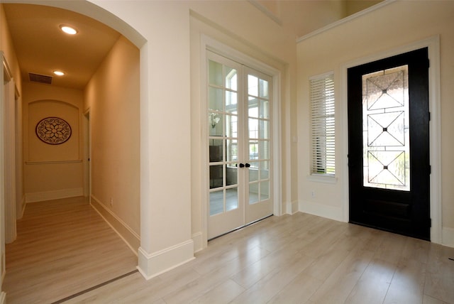 foyer with light hardwood / wood-style flooring and french doors