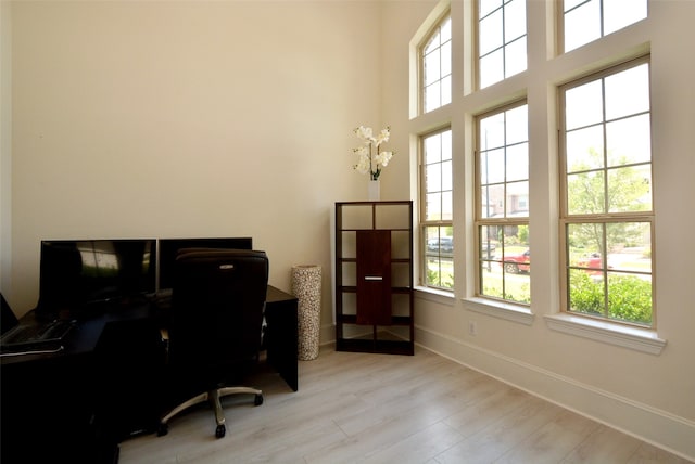 office space featuring light wood-type flooring and a healthy amount of sunlight