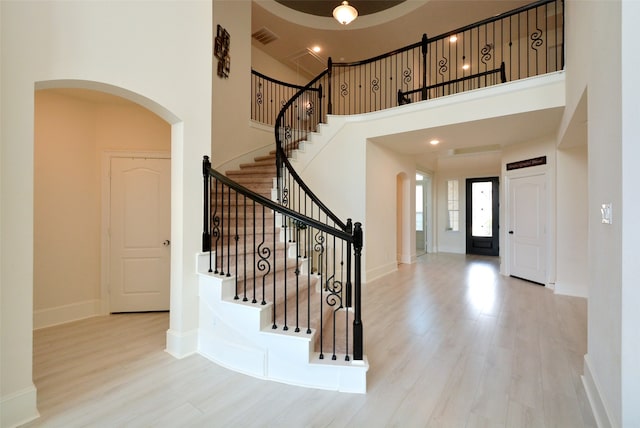 entrance foyer featuring a towering ceiling and light hardwood / wood-style floors