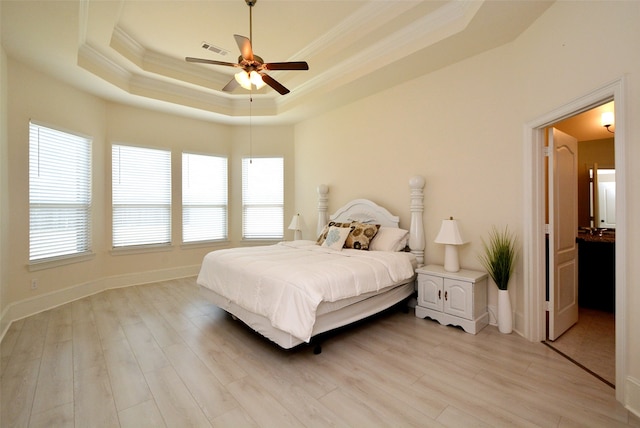 bedroom featuring a tray ceiling, light hardwood / wood-style floors, ceiling fan, and crown molding