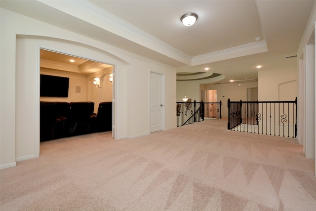 carpeted spare room featuring a raised ceiling and ornamental molding