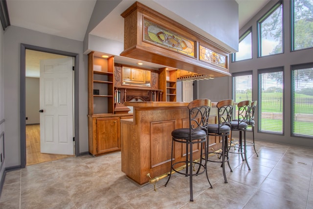 bar featuring high vaulted ceiling and light tile patterned flooring