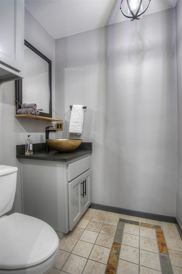 bathroom featuring vanity, a textured ceiling, and toilet