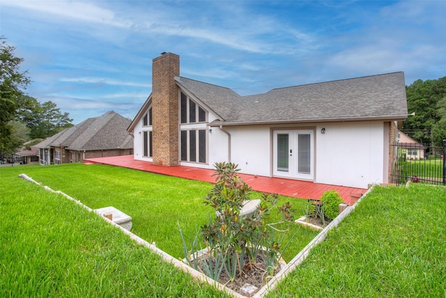 back of house featuring a yard, french doors, roof with shingles, stucco siding, and a chimney