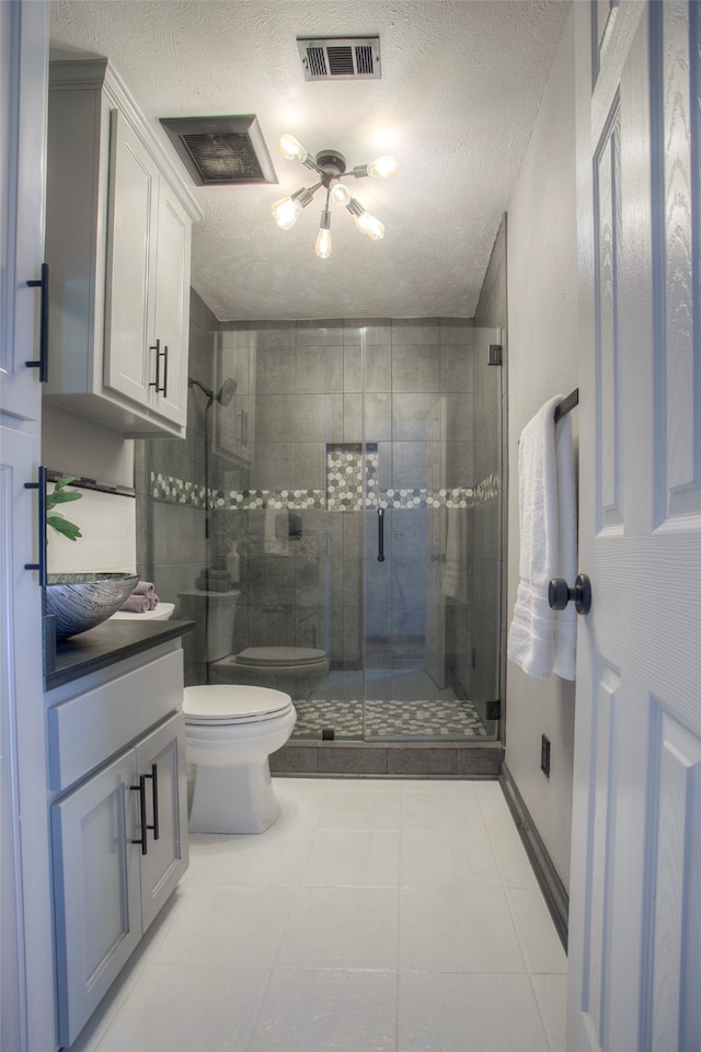 bathroom with tile patterned floors, a textured ceiling, and toilet