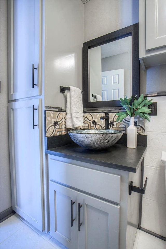 half bath featuring tile patterned floors and vanity