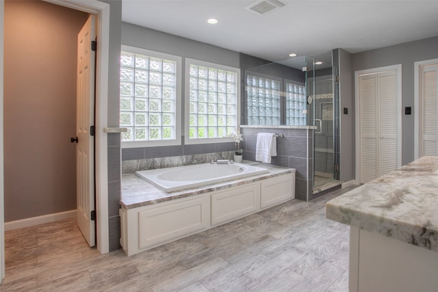 bathroom featuring shower with separate bathtub and vanity