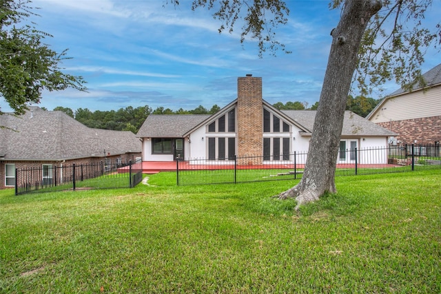 back of property featuring a lawn, a chimney, a fenced backyard, and stucco siding