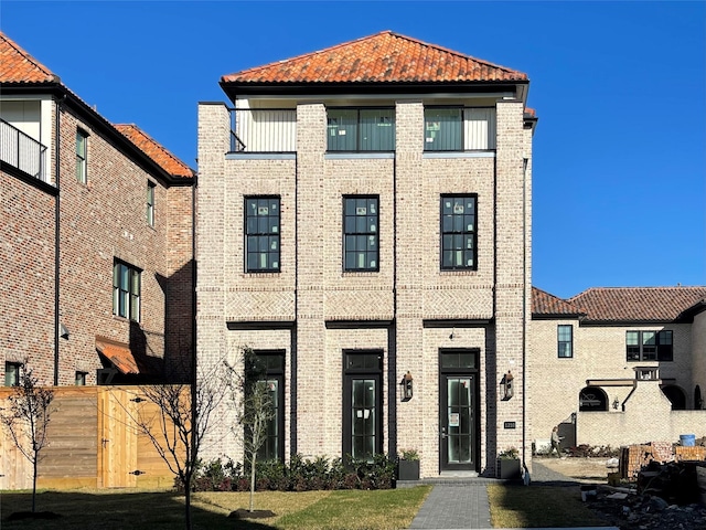 view of front of property featuring a tiled roof and brick siding