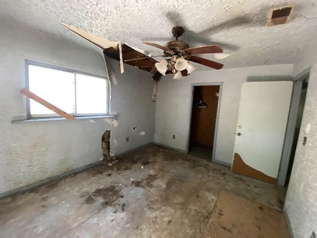 unfurnished bedroom with ceiling fan and a textured ceiling