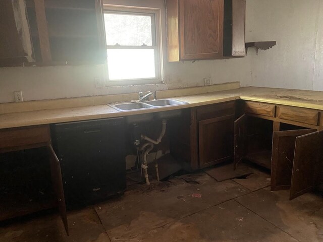 kitchen featuring dishwasher, a sink, and light countertops