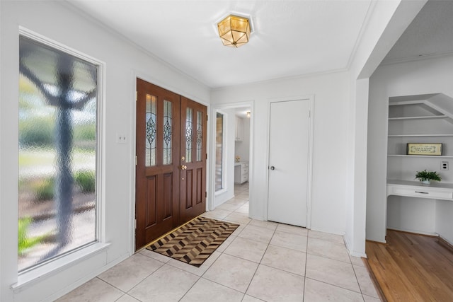 tiled foyer entrance featuring ornamental molding