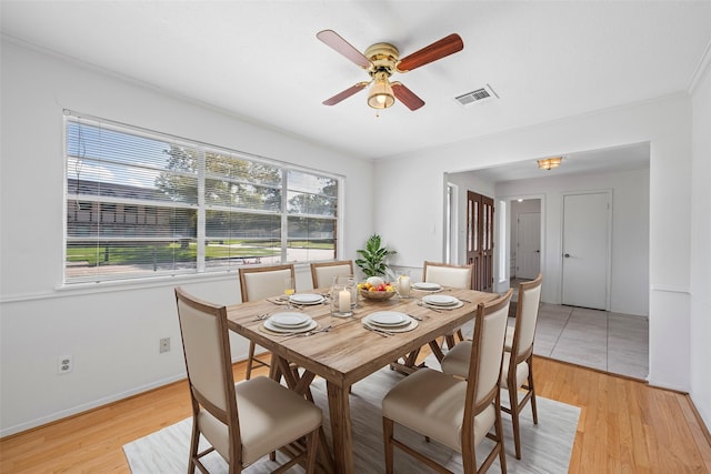 dining space with ceiling fan and light hardwood / wood-style flooring