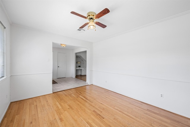 spare room featuring ceiling fan, ornamental molding, and light hardwood / wood-style floors