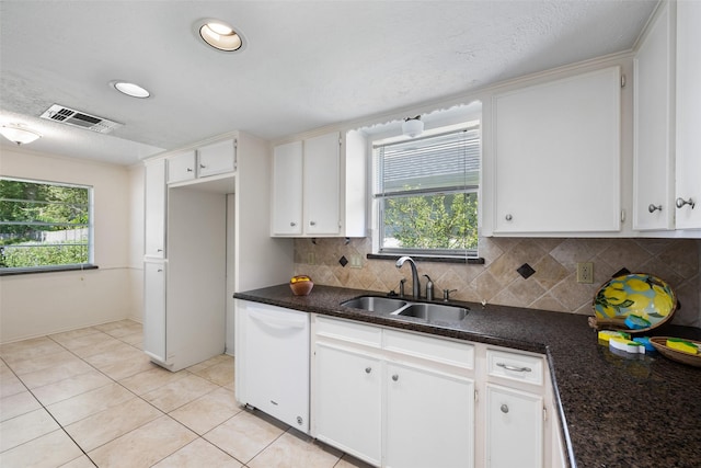 kitchen with sink, tasteful backsplash, white dishwasher, a healthy amount of sunlight, and white cabinets