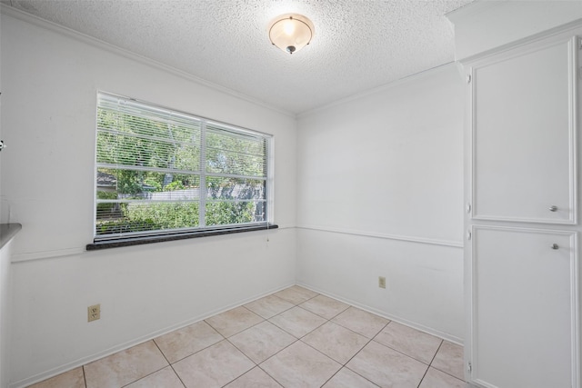 spare room with ornamental molding, a textured ceiling, and light tile patterned floors