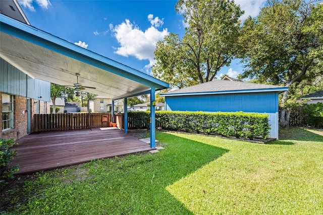 view of yard with a wooden deck and ceiling fan