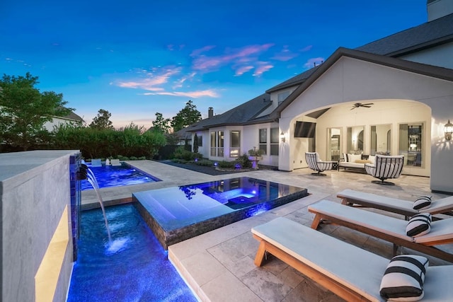 view of pool with an in ground hot tub, outdoor lounge area, pool water feature, and a patio area