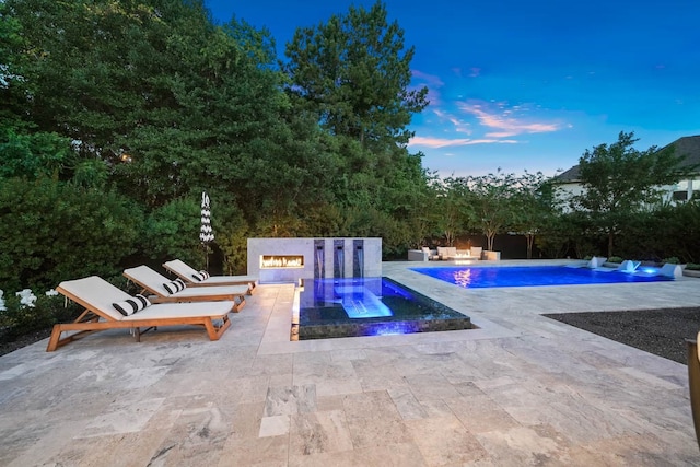 pool at dusk with a patio area