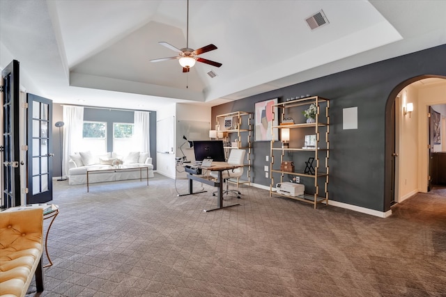 carpeted office space with ceiling fan, a raised ceiling, french doors, and vaulted ceiling