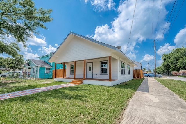 bungalow with a porch and a front lawn