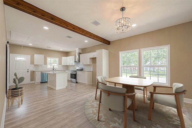 dining room with a chandelier, light hardwood / wood-style floors, beamed ceiling, and sink