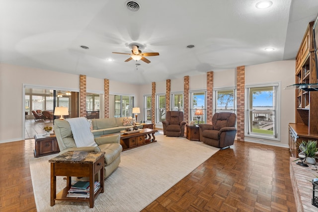 living room featuring ceiling fan, vaulted ceiling, and parquet floors