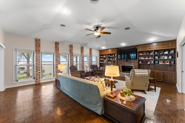 living room with lofted ceiling, a brick fireplace, dark parquet flooring, and ceiling fan