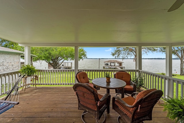 sunroom featuring a water view