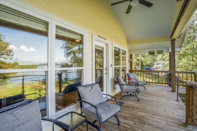 sunroom featuring a water view, vaulted ceiling, and ceiling fan