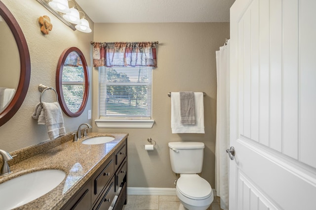 bathroom with tile patterned flooring, vanity, and toilet