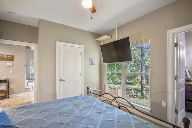 bedroom featuring connected bathroom, ceiling fan, and cooling unit