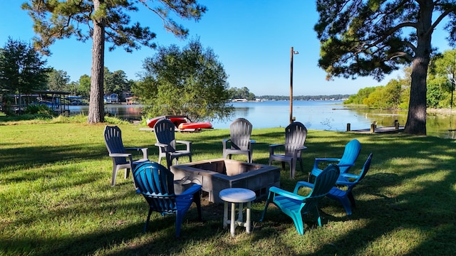 view of property's community featuring a fire pit, a water view, and a yard