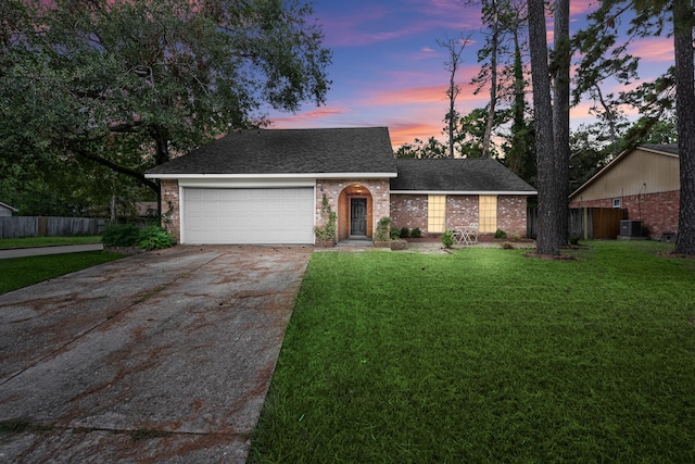 view of front of house with cooling unit, a yard, and a garage