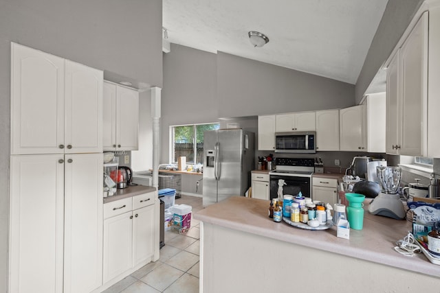 kitchen with white cabinetry, light tile patterned floors, stainless steel appliances, and high vaulted ceiling