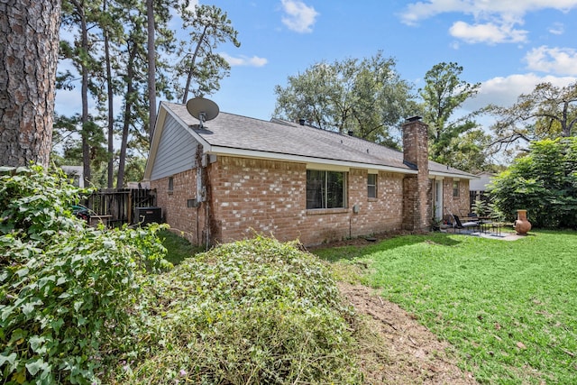 view of side of home featuring cooling unit and a lawn