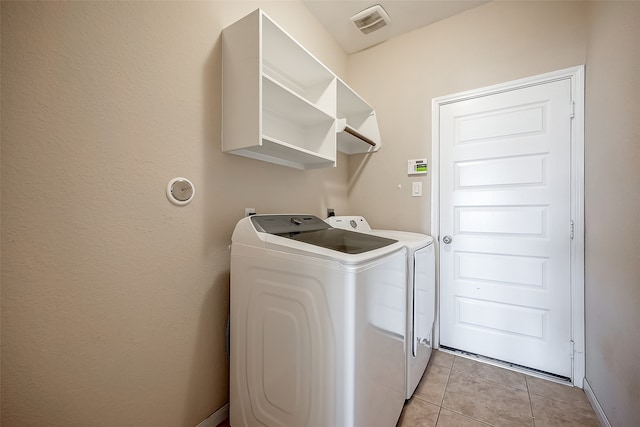 washroom with washing machine and clothes dryer and light tile patterned floors